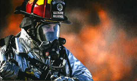 Firefighter standing in front of a fire