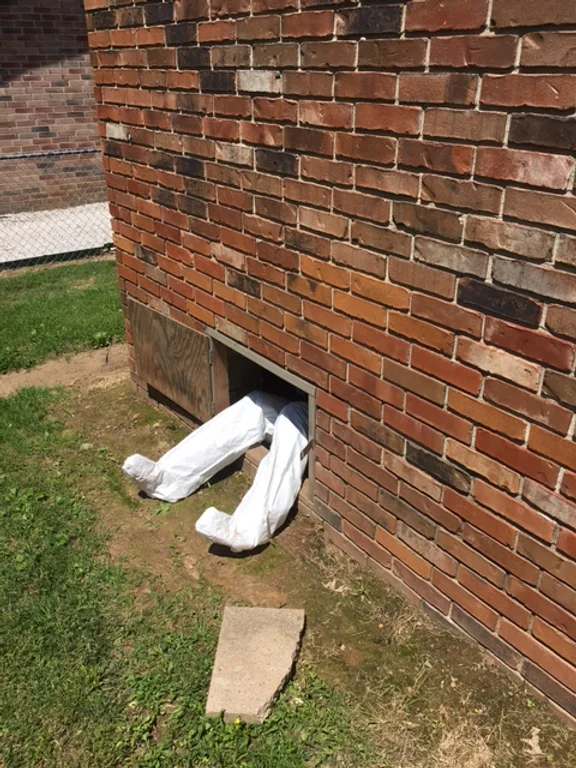 Man's legs sticking out from under a house.