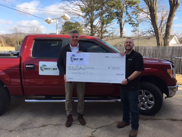 Two men holding a large check.